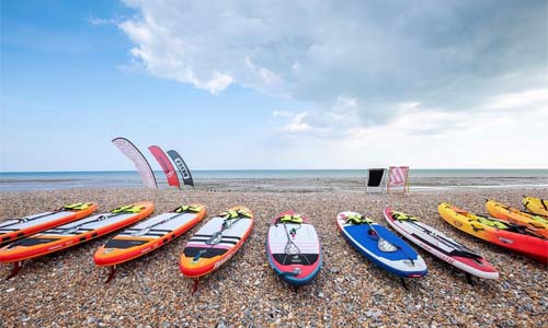 Worthing beach with some paddleboards on the pebbles 