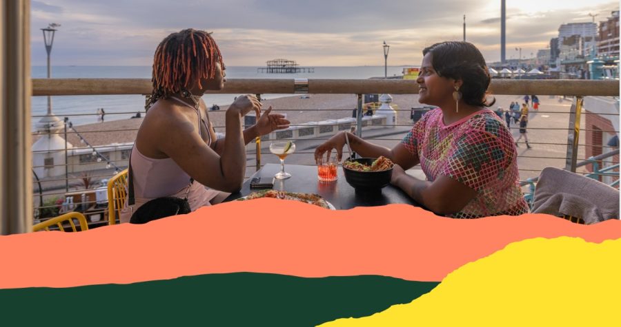 People sitting eating with West Pier in the background