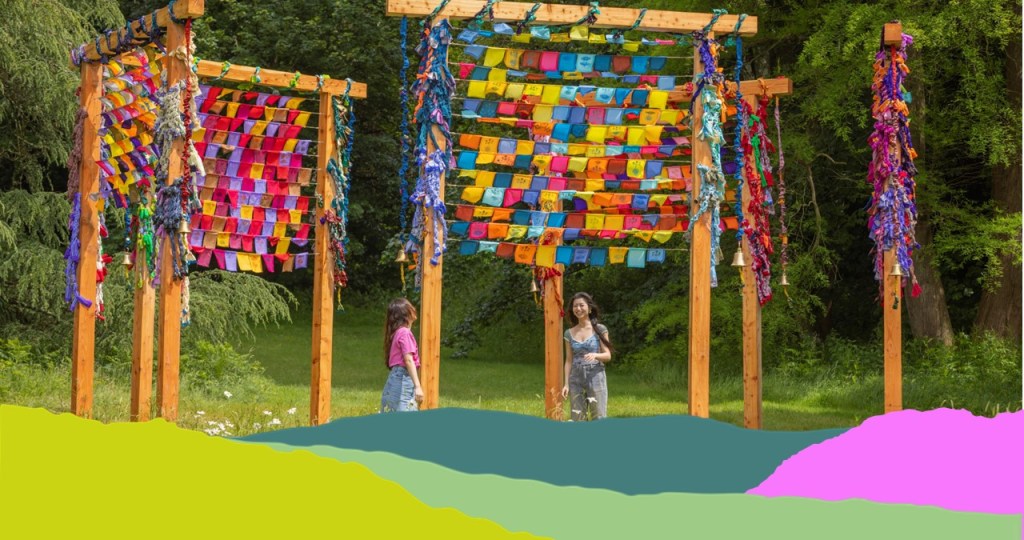 2 ladies standing under some very colourful bunting in rows at Wakehurst